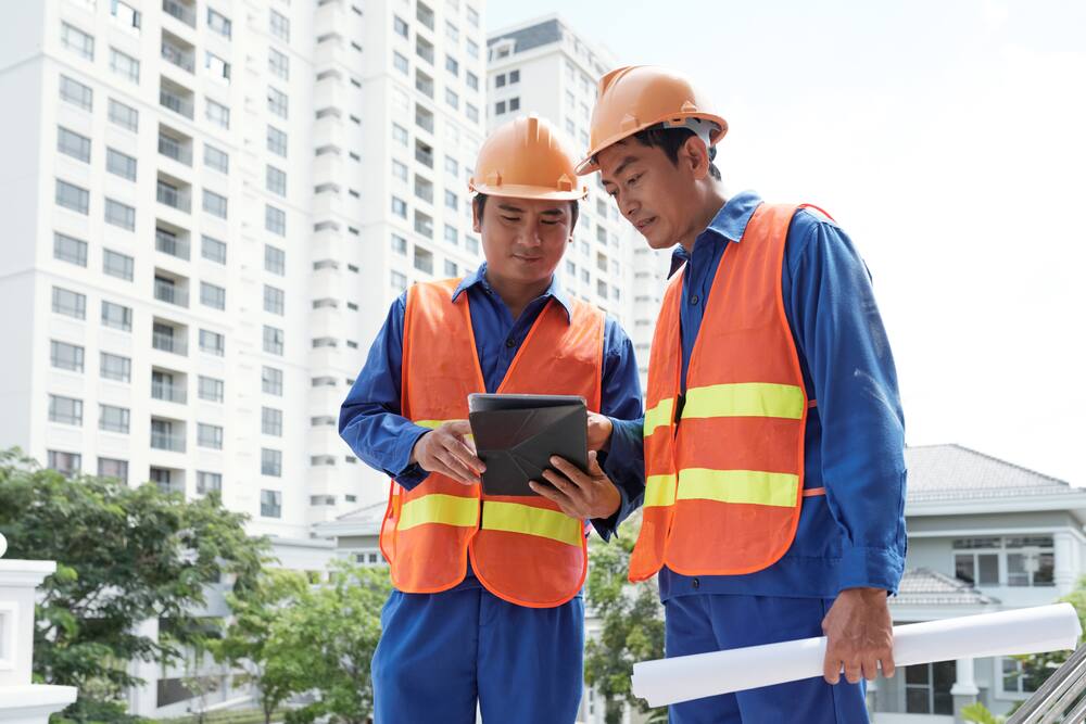 Two engineers reviewing data on a tablet at a site